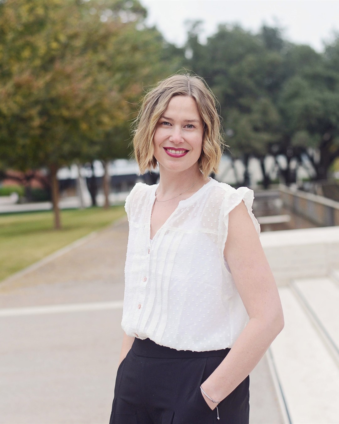 Laura Ikeda smiling outdoors at the Kimbell
